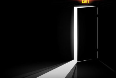 An exit door with a light shining through it, providing a symbol of hope for executives and CEOs.