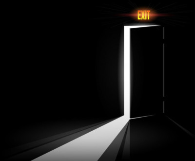 An exit door with a light shining through it, providing a symbol of hope for executives and CEOs.