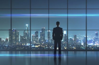 A CEO standing in front of a window with a city view.