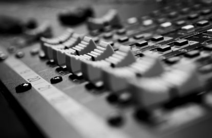 A black and white photo of a mixing board used by executives.