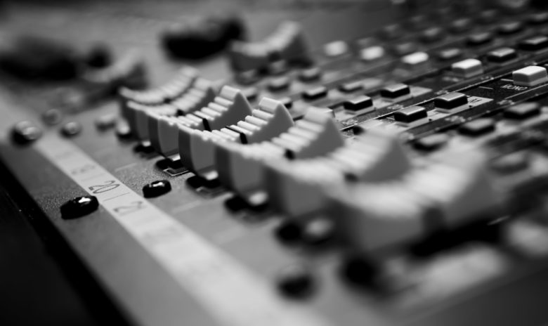A black and white photo of a mixing board used by executives.